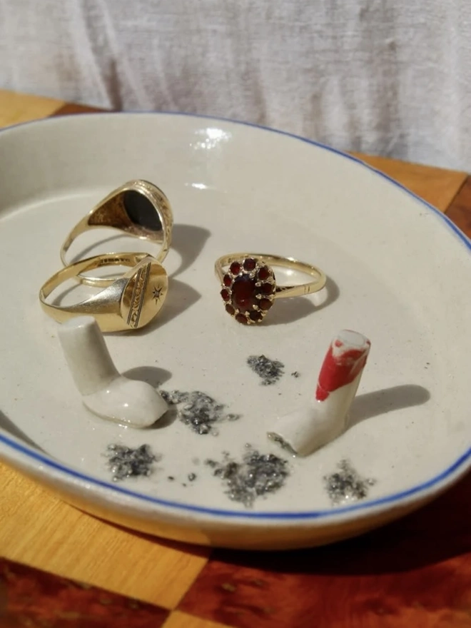 Still Life Trinket, a collection of trinkets sitting on a plate on a wooden surface.  Dish