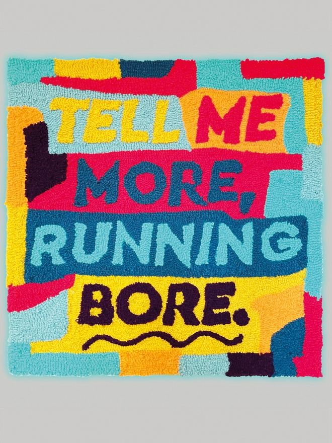 tell me more running bore written in bright coloured tufted wool on an abstract geometric background