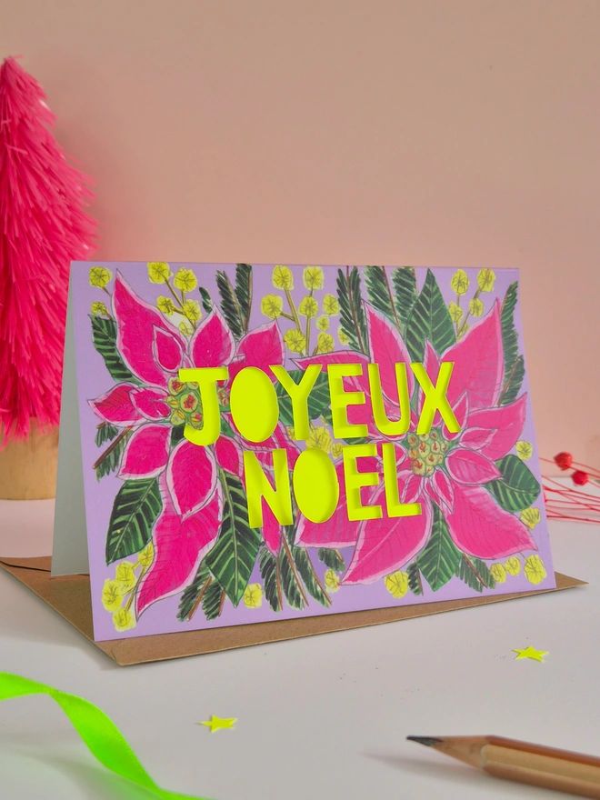 Pink poinsettia Christmas Card with paper cut Joyeux Noel text and neon yellow backing paper 