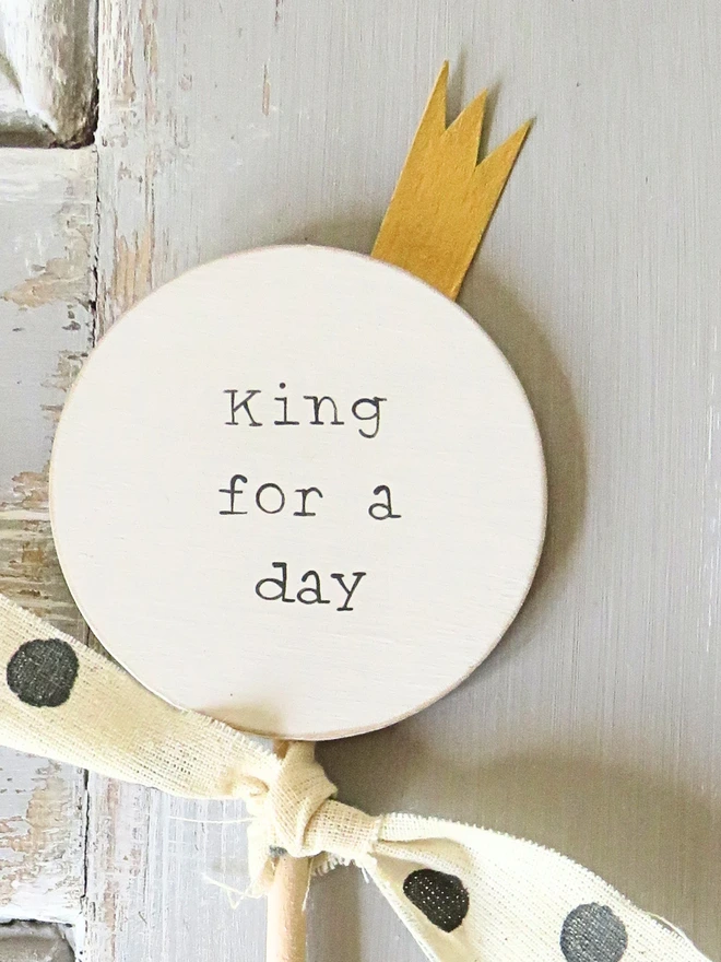 wooden circle shaped cake topper with hand painted message, gold painted crown detail and custom ribbon
