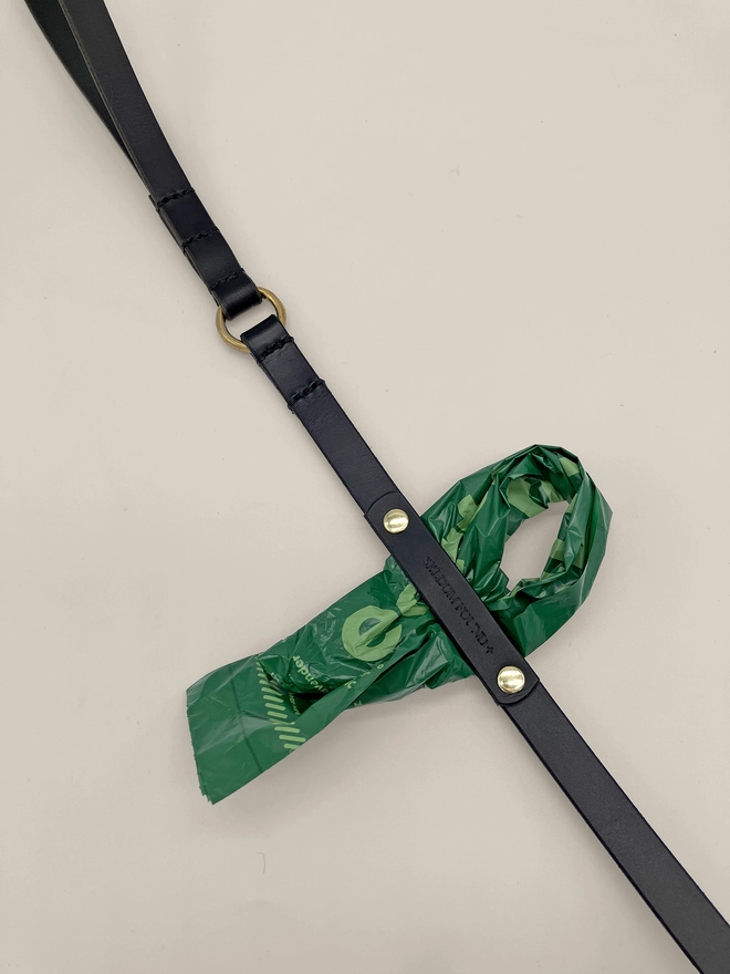 close up of black leather dog lead with dog bag