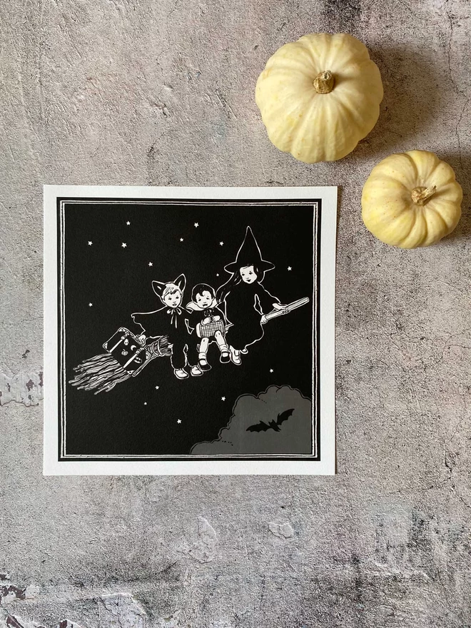 a cute spooky halloween print of a witch and vampire and baby bat on a broom stick