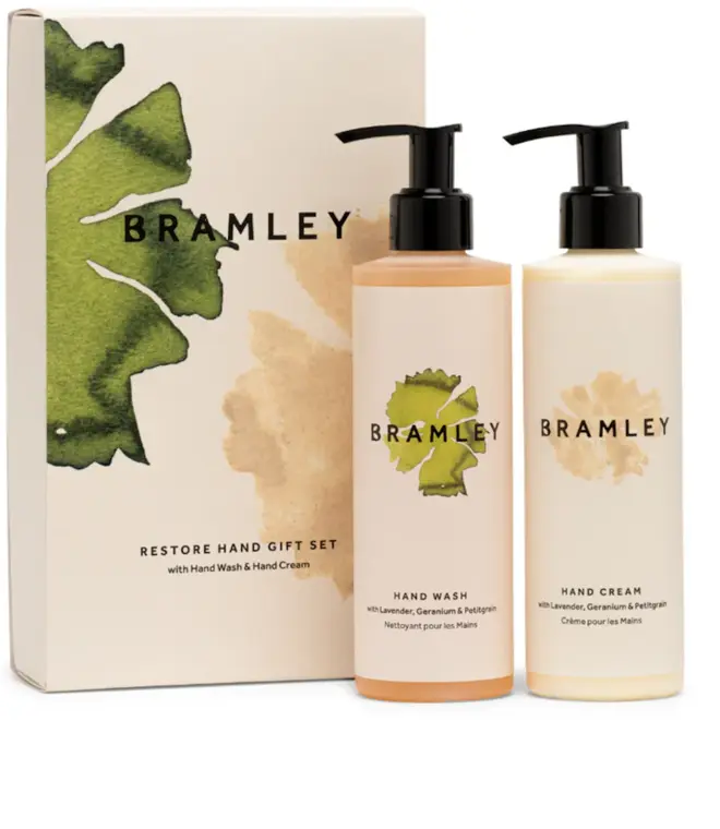 two bottles of product with white labels and black caps, next to a white box with green and pink floral design