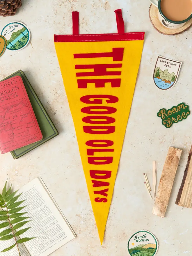 The good old days pennant flag in red and yellow with patches and books around it