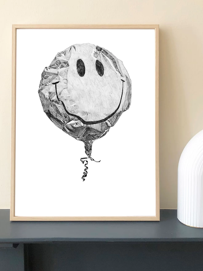Art print of a handrawn smiley balloon displayed in a frame