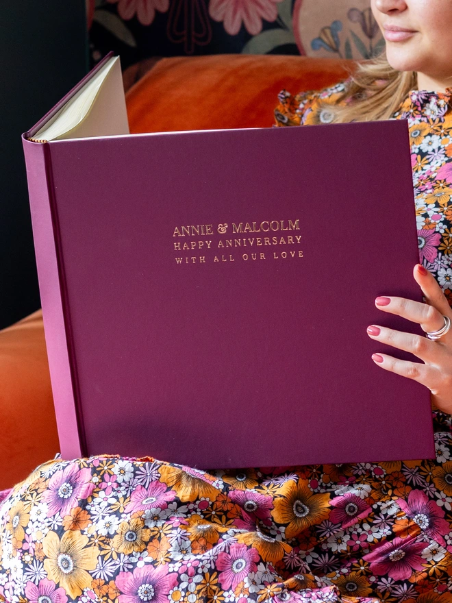 A woman looks inside a Handmade & Personalised Anniversary Photo Album, printed on the front cover.