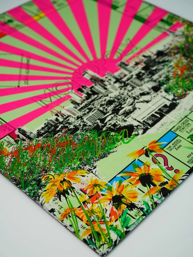 Corner of a Monopoly board close up with pink stripes and coloured flowers and London view printed on top  