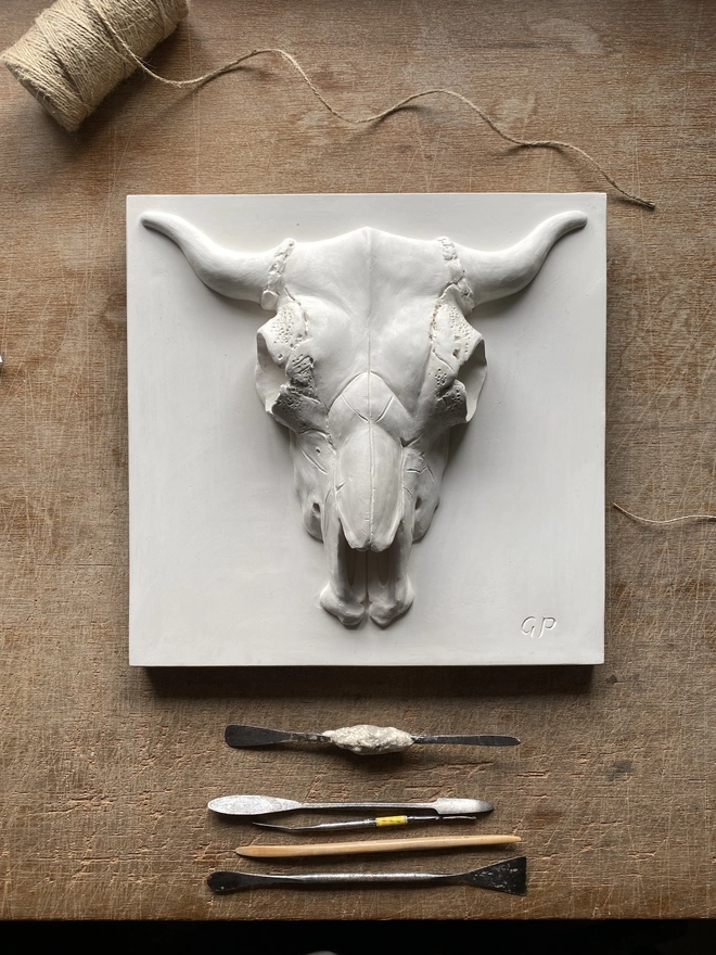 Plaster bas-relief wall plaque of a Bucranium skull design with tools