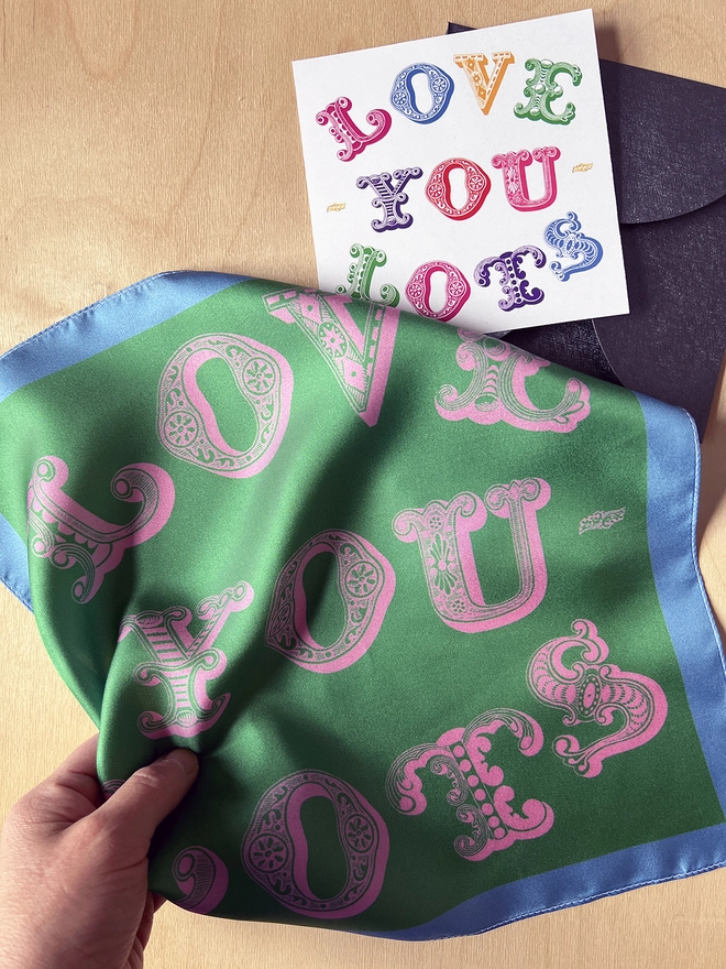 A hand clasps a Mr.PS Love You Lots Silk Square and the included card