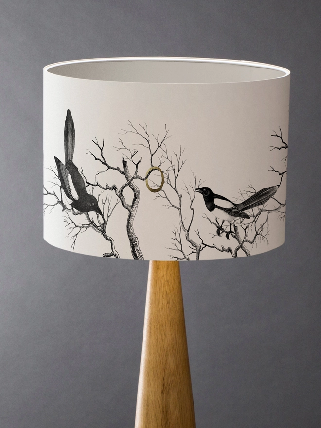 Drum Lampshade featuring magpies sitting on branches with a white inner on a wooden base 