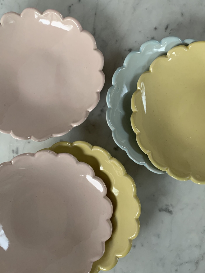 top view of pink, yellow and light blue ice cream bowls with camellia scalloped edge