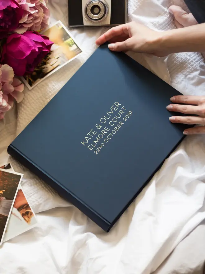 A Personalised Large Landscape Wedding Guest Book positioned on a white table cloth. 