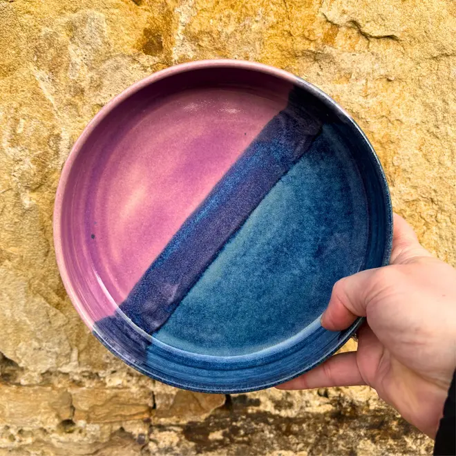 Landscape Pasta Bowl, a colourful pasta bowl held against a brick backdrop. 