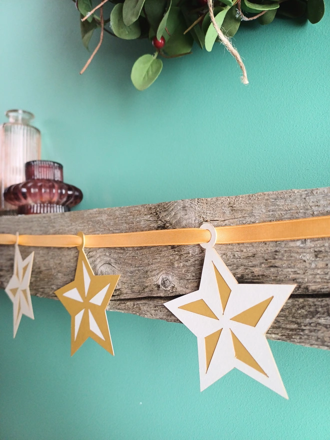 Gold and White Star Garland on Mantelpiece, Decorations Alternate between White and Gold 5 Pointed Stars