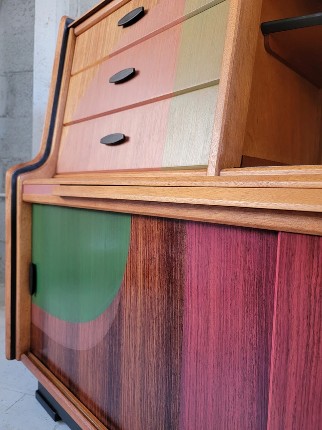 Close up of sliding doors on teak mid-century sideboard upcycled with pink and green shapes