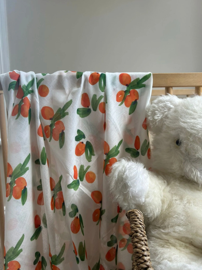 Clementines Muslin. A muslin patterned with clementines draped over a chair.