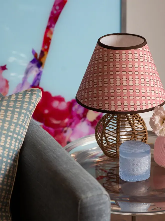 pink lalli empire lampshade on wicker base on table