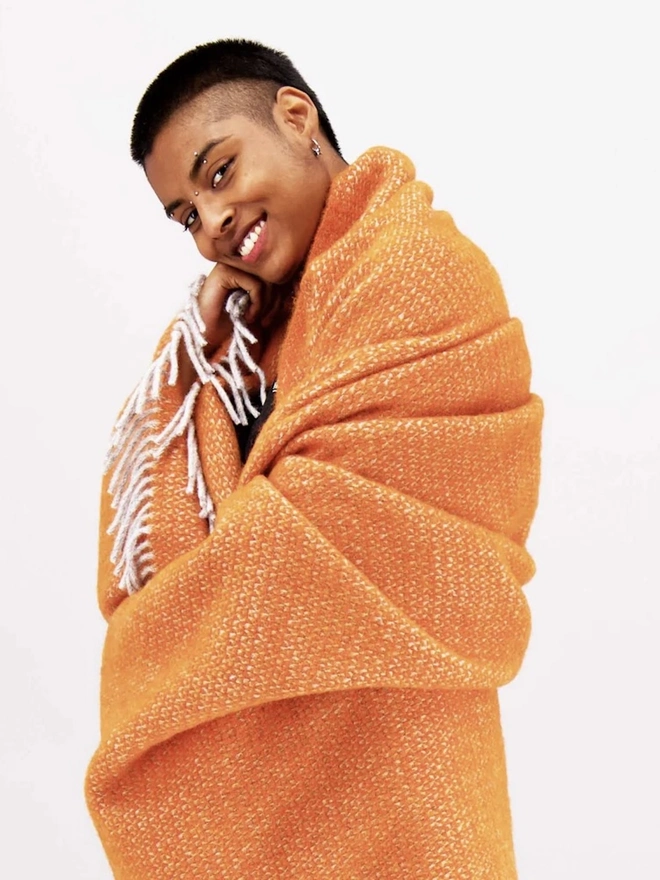 Organic Wool Throw, a person with the wool throw draped over them. 