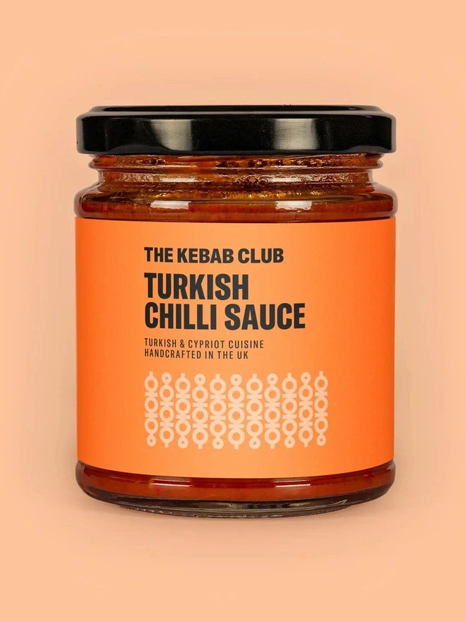 jar of turkish chilli sauce on orange background