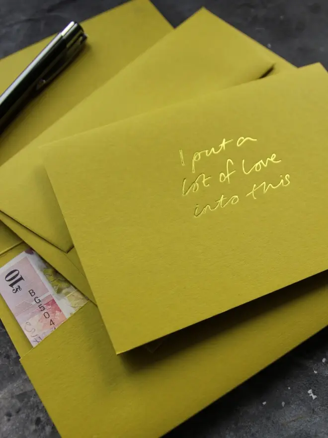 Hand foiled cash card or money wallet in a chartreuse green colour handfoiled in shiny yellow foil text which says ‘I put a lot of love into this’.