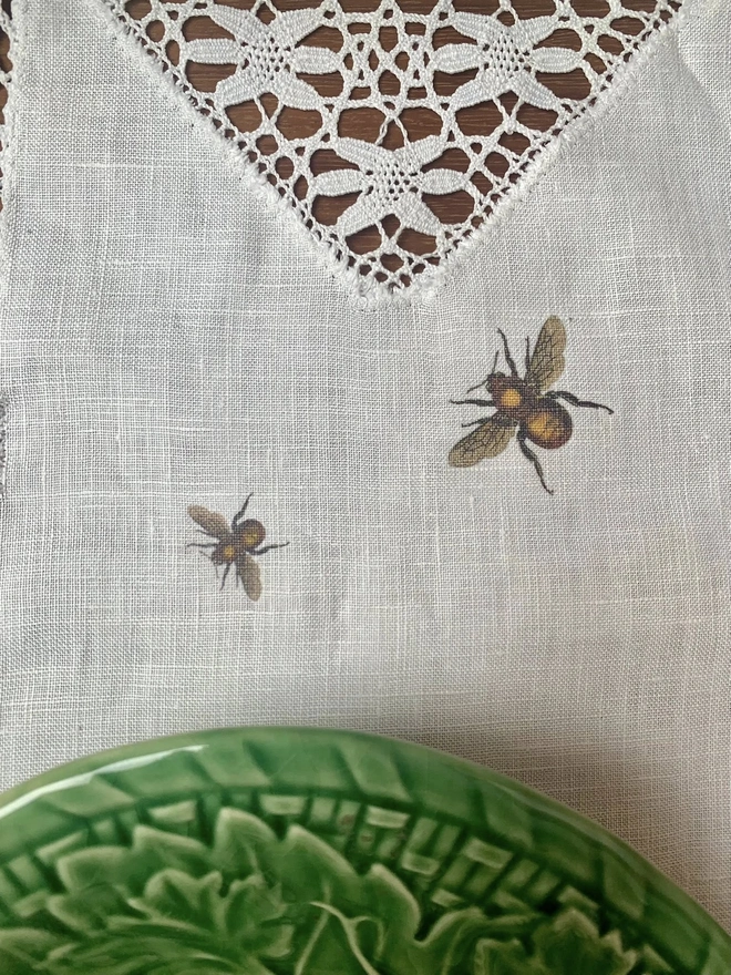 An upcycled vintage linen and lace table runner with printed bees