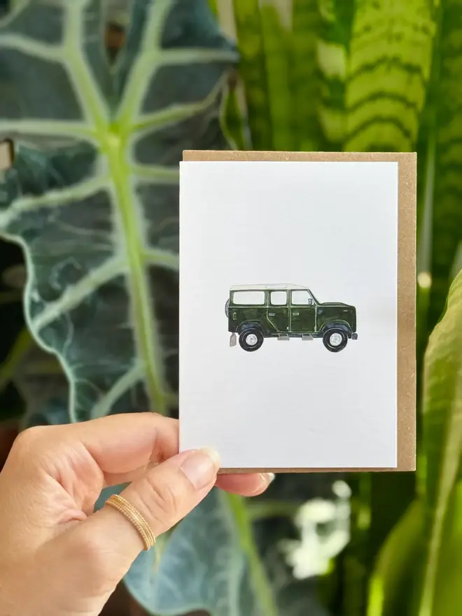 land rover defender illustrated mini card. card photographed with houseplant in background.