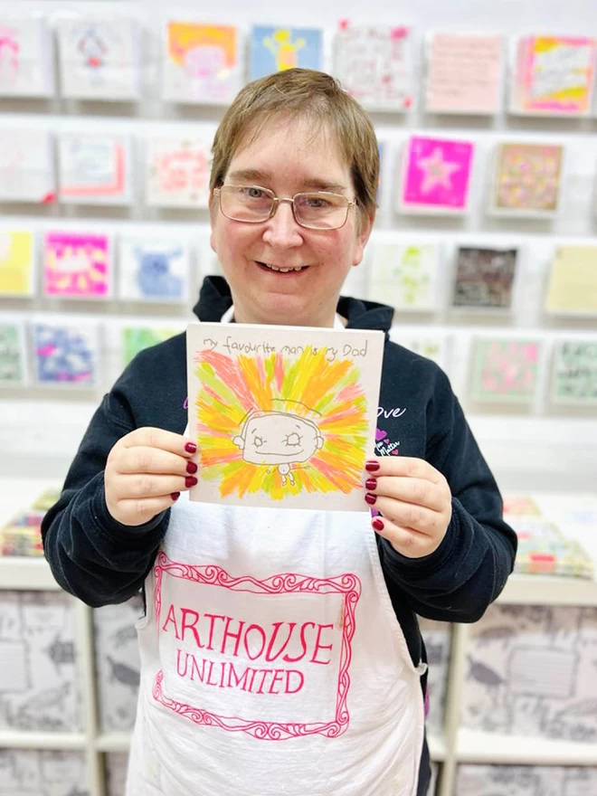 Artist holding My Favourite Man Is My Dad riso printed card with a simple positive sketch of a Dad 