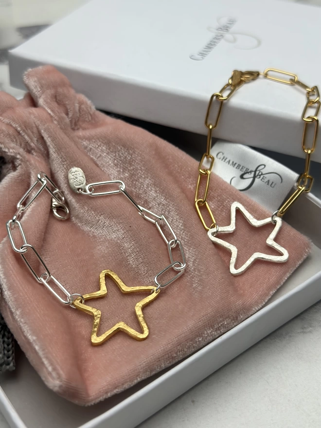 rustic sterling silver star charm on gold paperclip chain, and a rough hewn gold open star charm on sterling silver paperclip chain. gift box and pouch