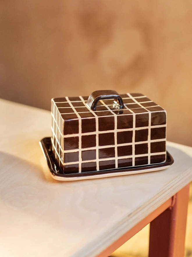 Grid Butter Dish, a colourful butter dish with a grid pattern sitting on a white tabletop surface. 