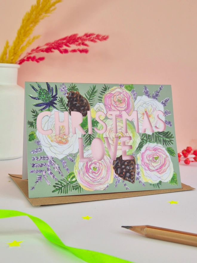 Pretty rose illustration christmas card with Christmas love paper cut text and metallic pink backing paper 
