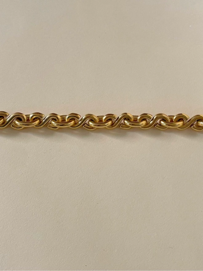 an iconic design gold chain bracelet with an S O S pattern