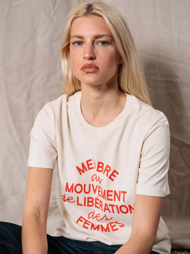 A model wearing a Black & Beech oversized raw cotton t-shirt with the words 'Membre Du Mouvement De Libération Des Femmes' written in red across the front