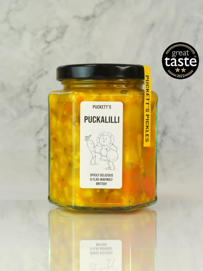 puckalilli piccalilli. a jar of piccalilli photographed on a marble background.