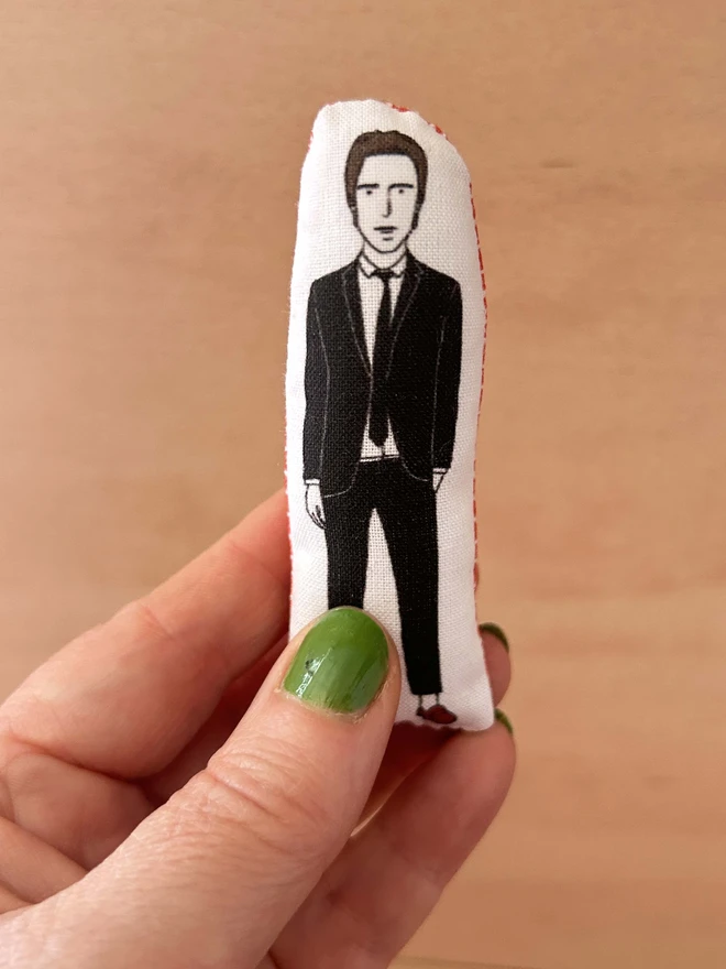 Mini fabric doll featuring illustration of Paul Weller held in a hand.