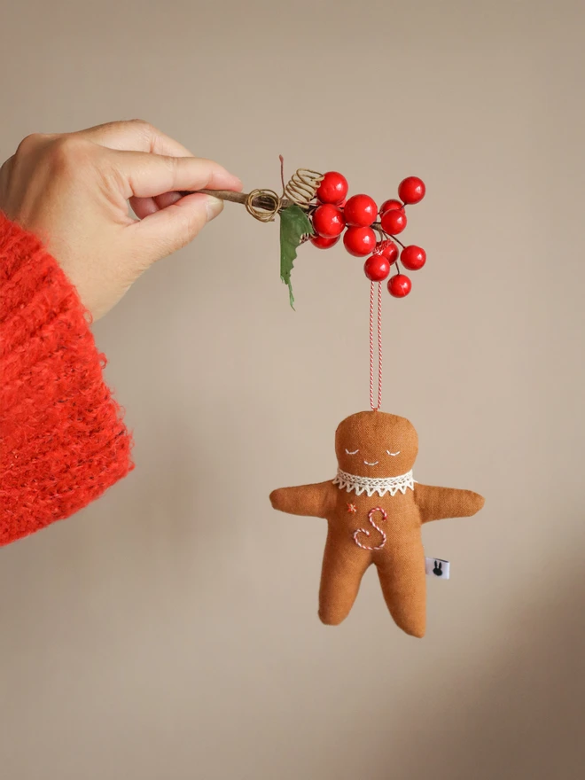 christmas tree ornament with a letter hand embroidered in candy cane colours, star shaped sequin, crochet cotton lace around the neck, smile embroidered in white and candy cane colour string to hang.