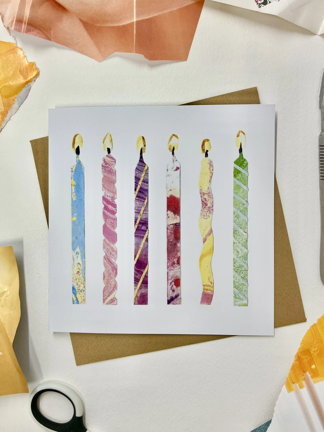 Birthday card showing six colourful collaged candles on a background of collage materials