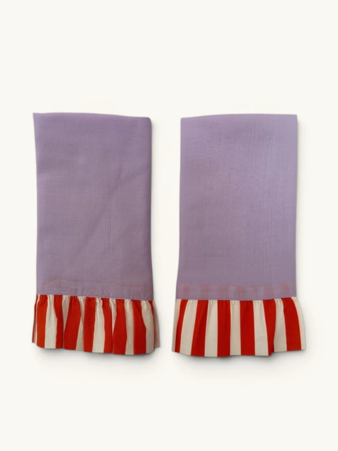Pair of Ruffle Napkins. A pair of napkins, folded, in lavender and tangerine.