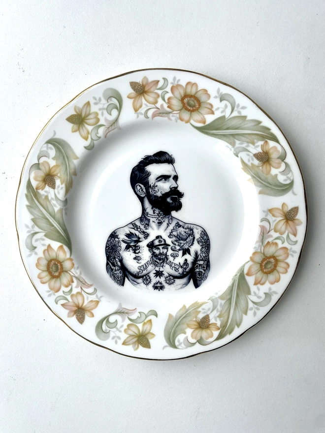 a vintage plate with ornate border, within the centre i have printed the vintage style image of a victorian tattooed sailor man