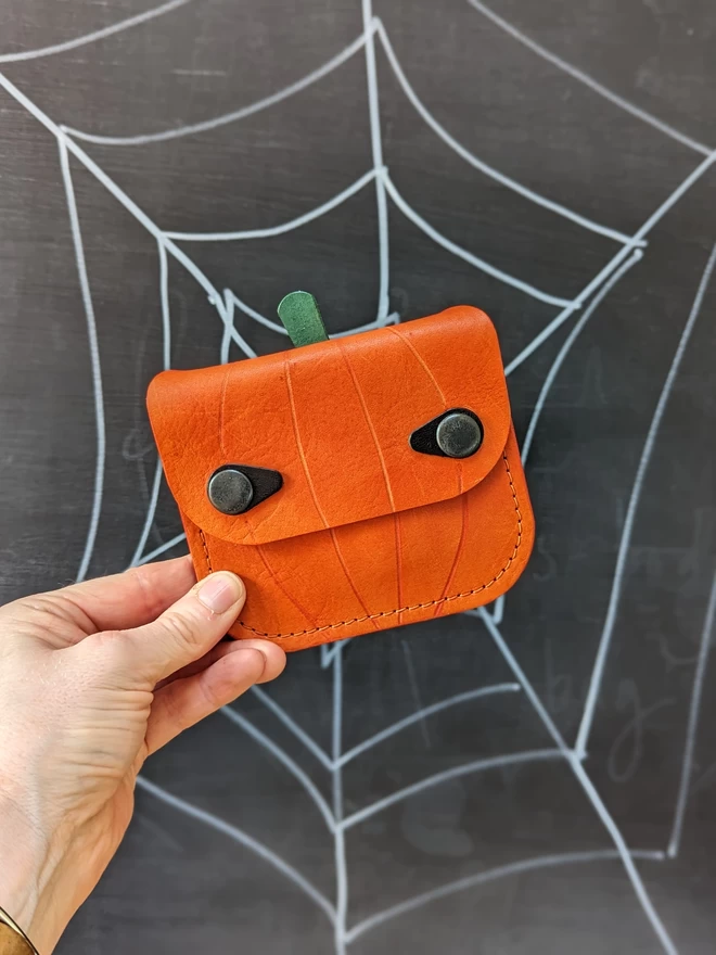 Front view of handmade leather Jack O' Lantern pumpkin purse.