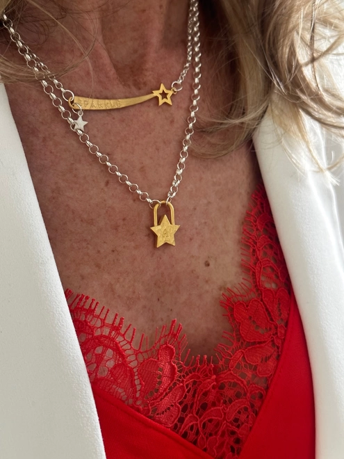model wearing silver chain with gold shooting star charm and small silver star charm, and sterling silver chain with gold star padlock