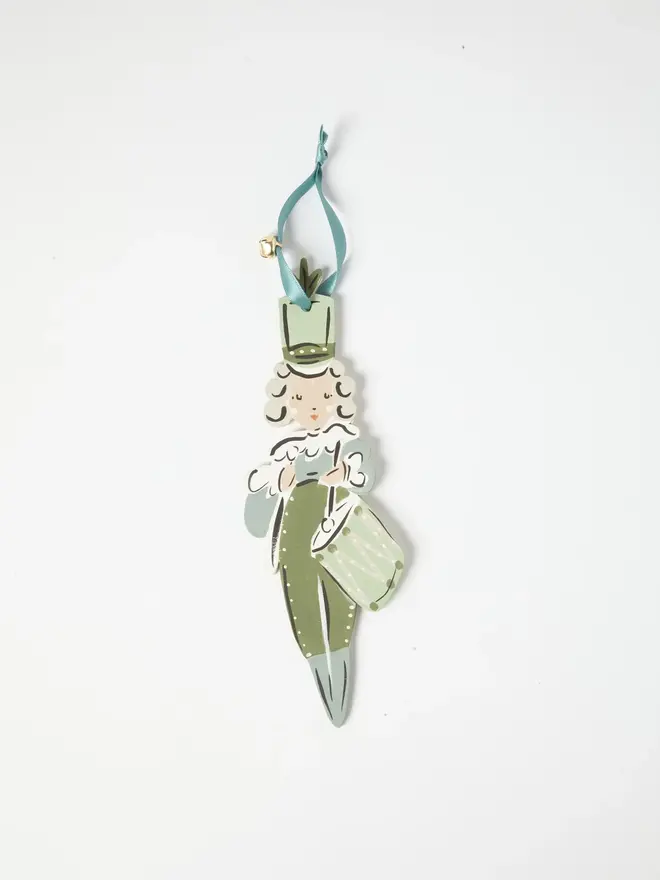Little Drummer Tree Dancer. wooden hanging little drummer decoration with a curly white wig, sage green hat, uniform and drum, duck egg blue ribbon with a jingle bell, on a white background