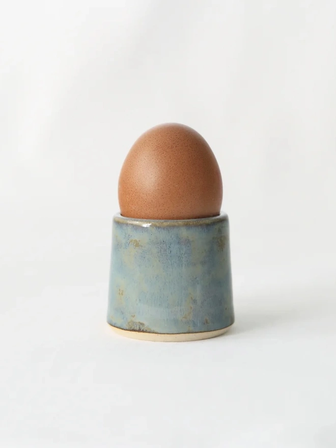 Classic Handmade Egg Cup, a ceramic egg cup sitting on a plain surface against a white backdrop. 