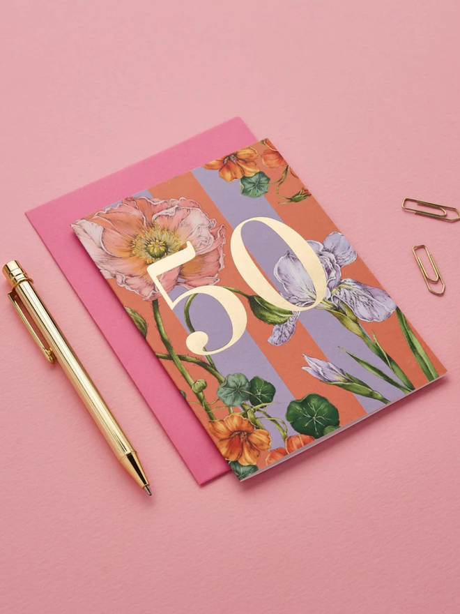 floral age milestone card. a pink floral 50th birthday card photographed against a pink background.