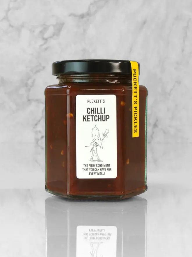 chilli ketchup. a jar of chilli ketchup photographed against a marble background. 