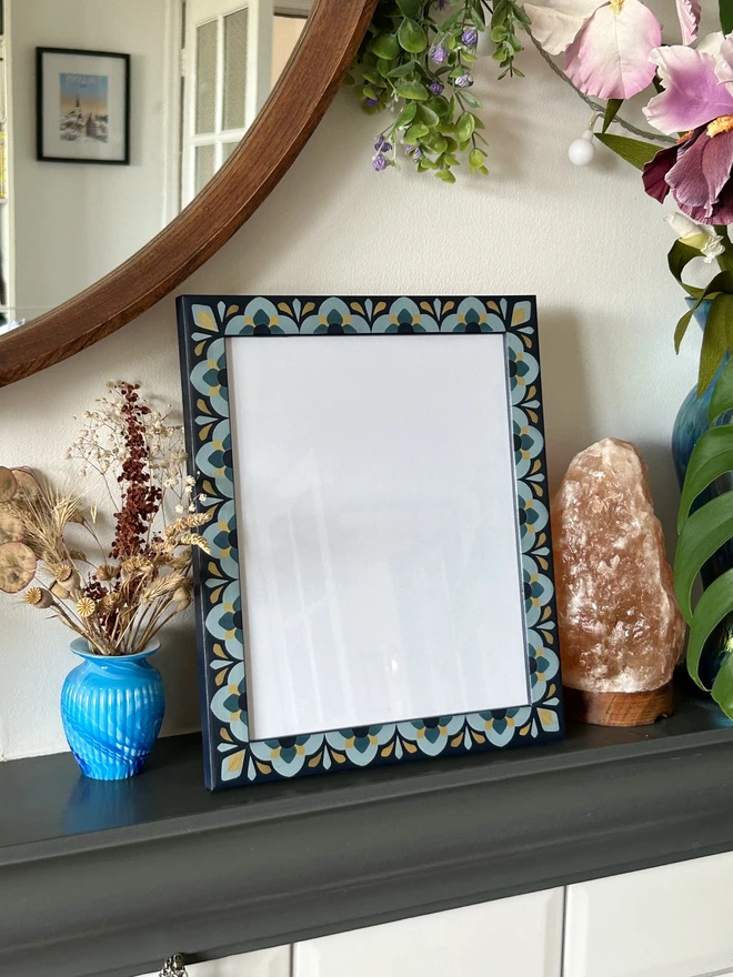 Heavily patterned medium sized picture frame hand painted in shades of blue with gold details