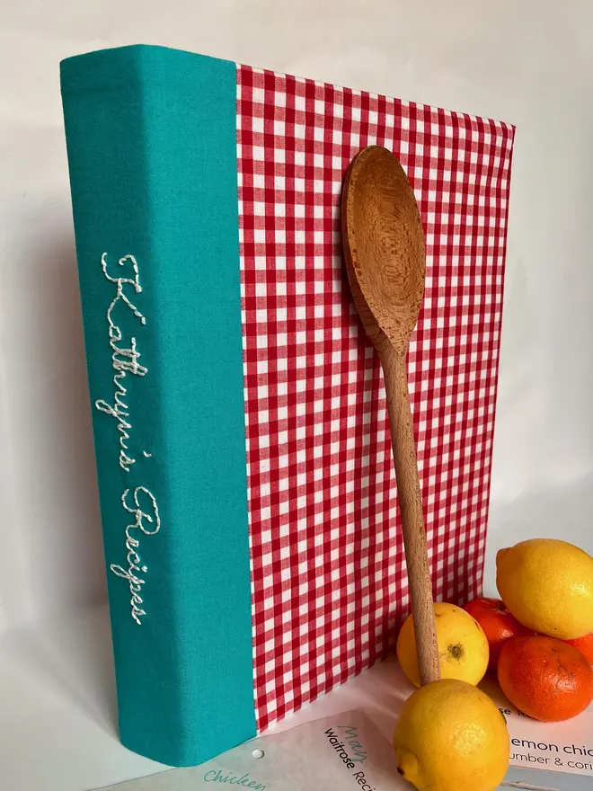 Red gingham binder, personalisation embroidered on the teal spine, lemons & oranges besid