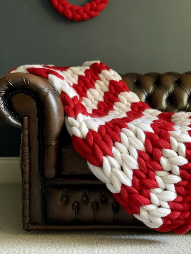 A close up of a red and white striped candy cane giant knitted blanket