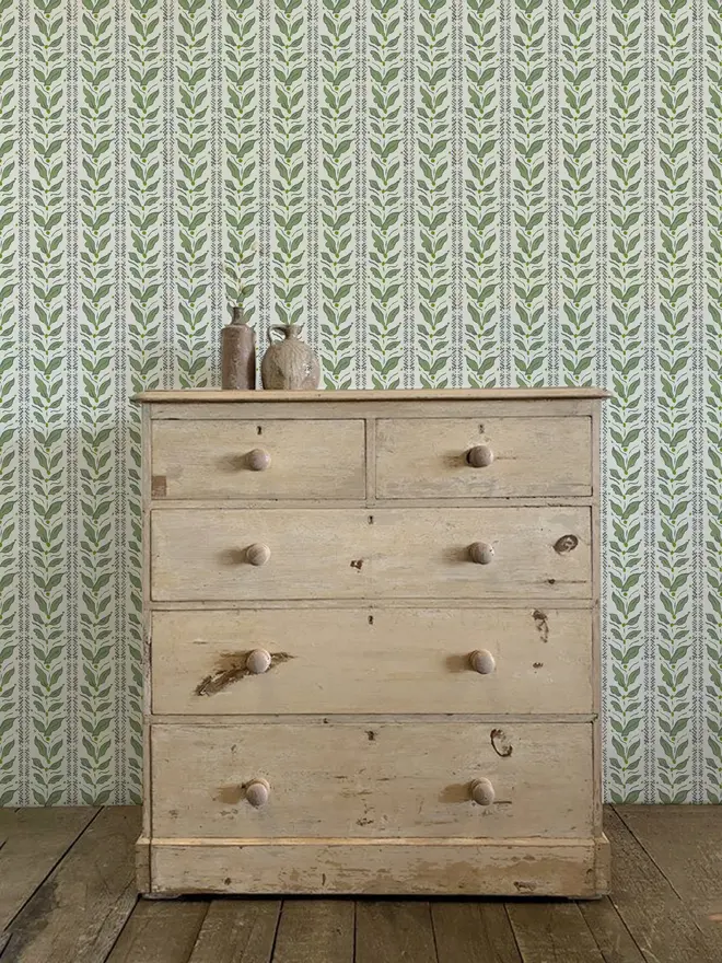 leaf stripe illustrated wallpaper. a green leaf patterned wallpaper on a wall.