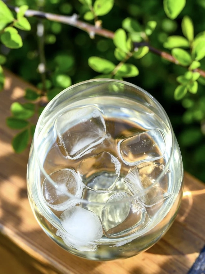 Elderflower Cordial (Set Of 1, 2, 3 Or 4), a glass of cordial sitting on a wooden surface. 