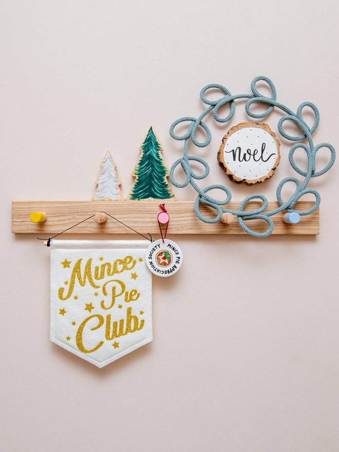 Christmas "Mince Pie Club banner" in white felt with yellow gold glitter font. The text is surrounded by glittery stars